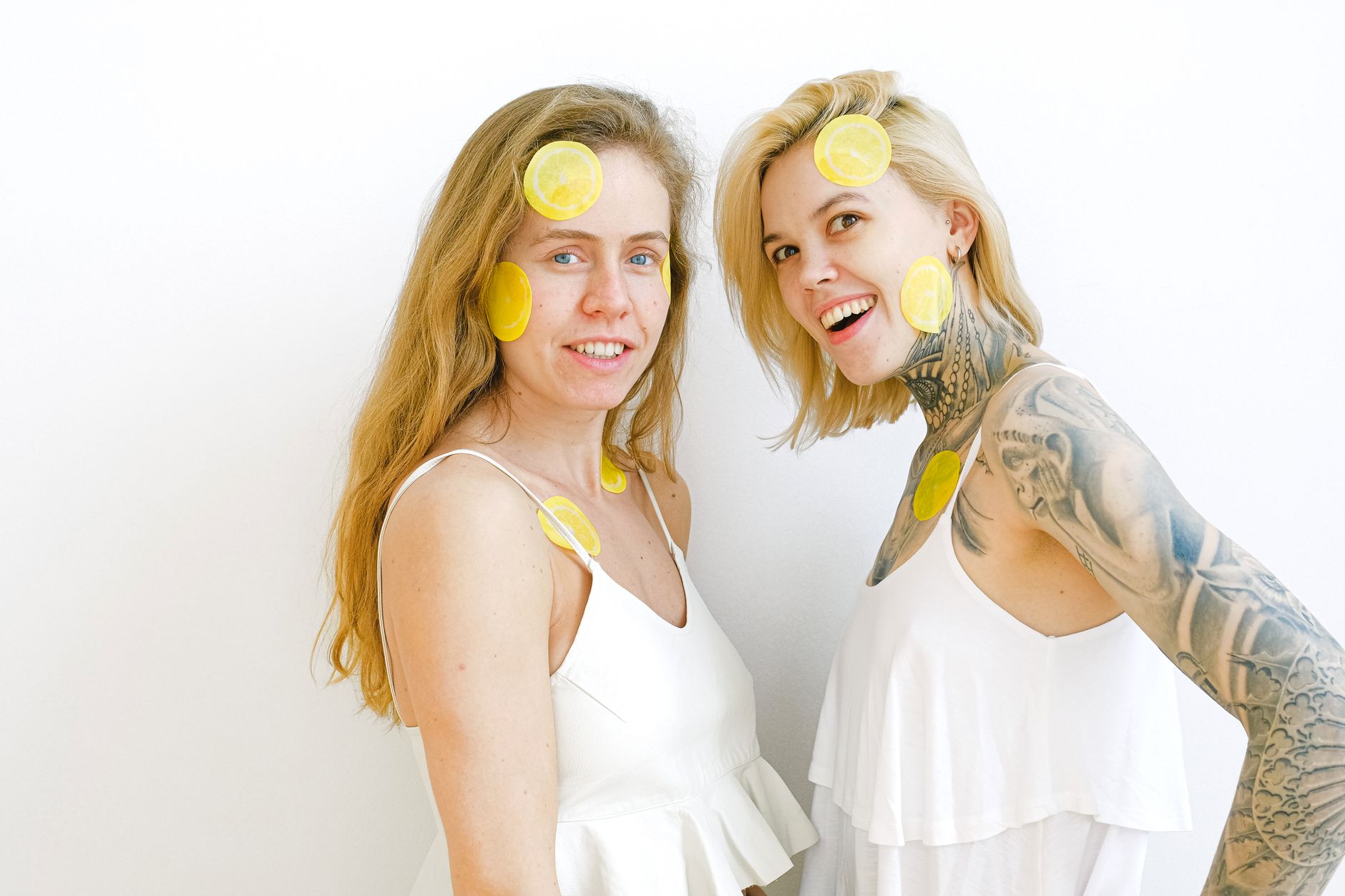 Hand holding a fresh lemon on soft pink background, symbolizing gentle skin care and natural sensitivity