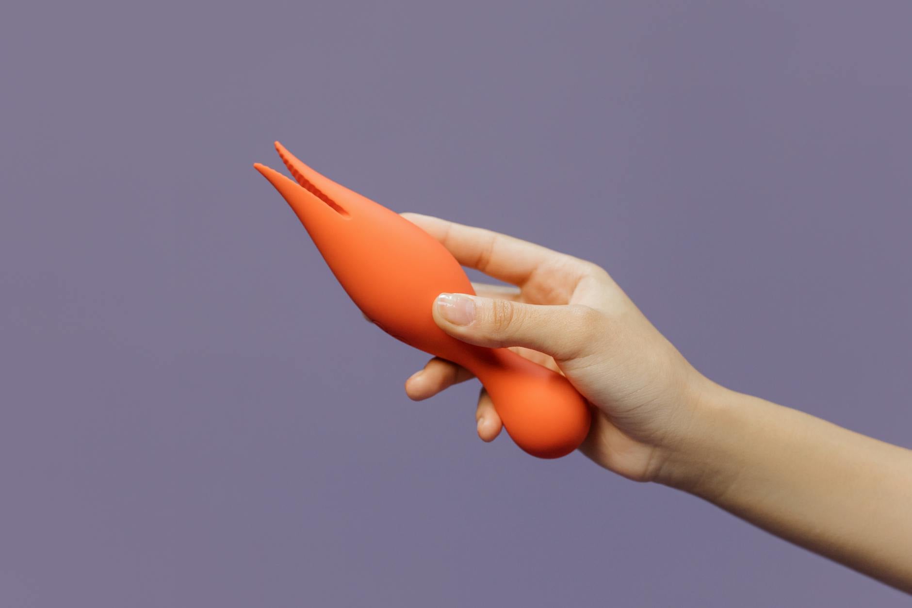 Hand holding a lemon vibrator against a purple backdrop, symbolizing sensual self-care during stressful seasons