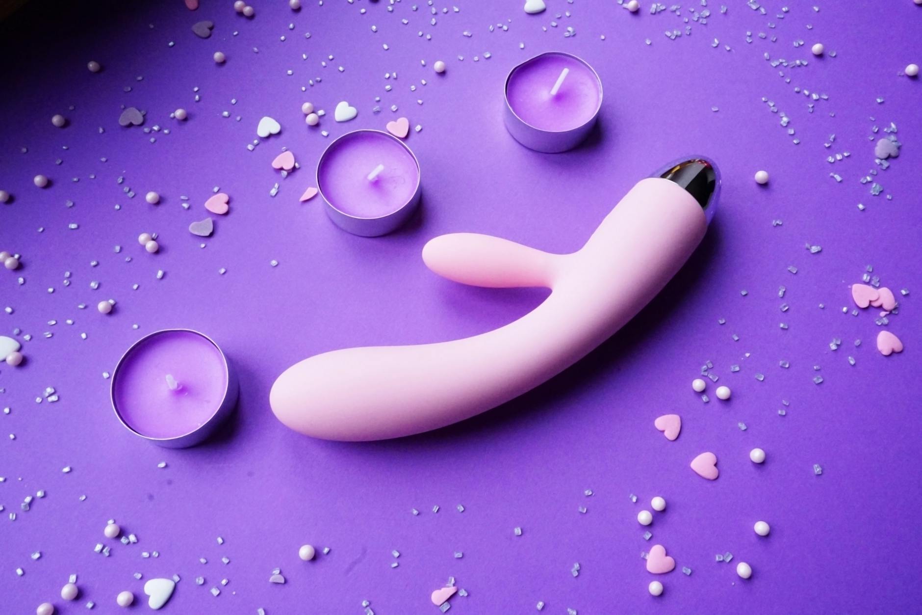 Vibromasseur orange sur un fond minimaliste violet, symbolisant la sensualité moderne et la confiance retrouvée