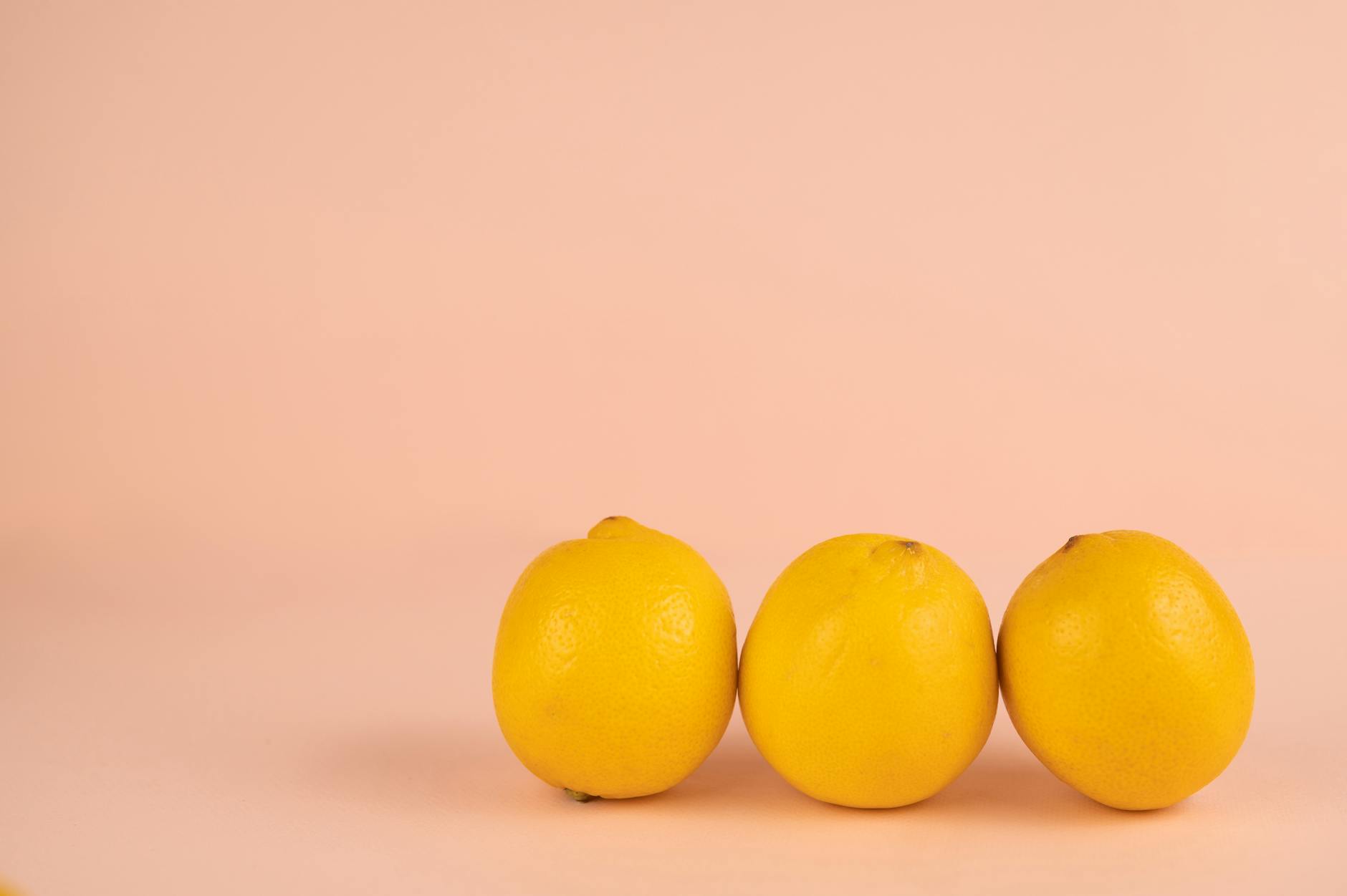 Bright ripe lemons on a pastel background, symbolizing fresh pleasure and sensation