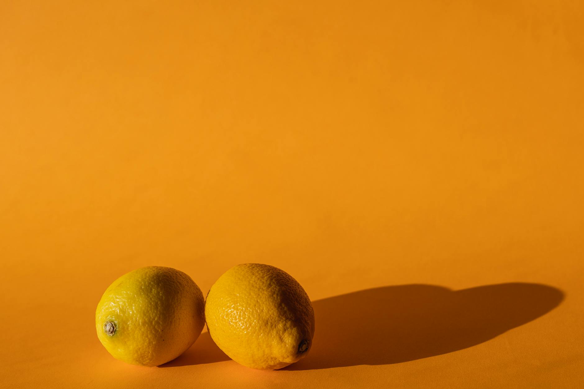 Ripe lemons on a bright yellow background, symbolizing freshness and natural vitality